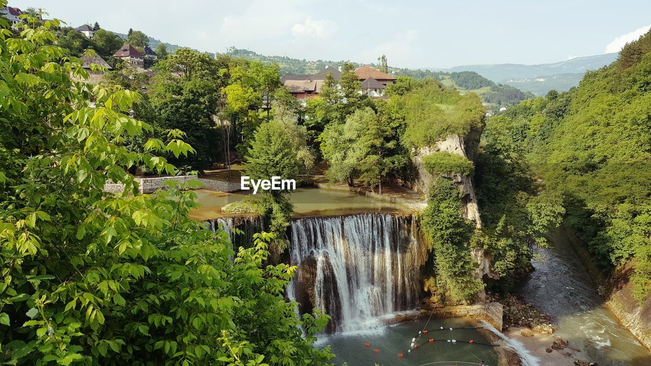 SCENIC VIEW OF WATERFALL AGAINST SKY