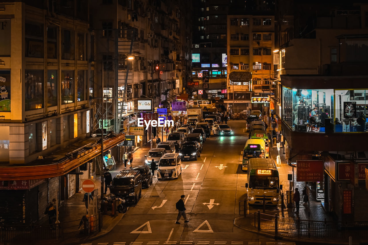 High angle view of illuminated street amidst buildings at night