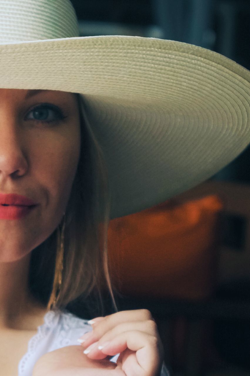 Close-up portrait of beautiful young woman wearing hat