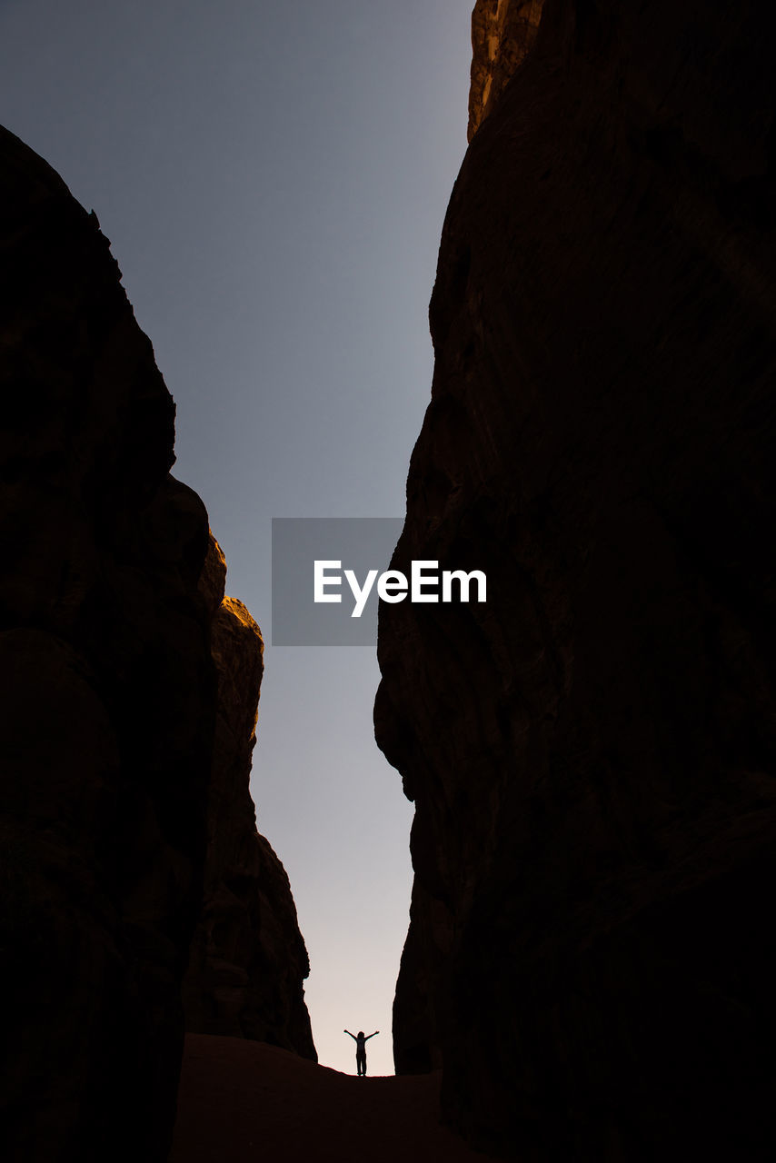 Low angle view of silhouette rock formations against sky