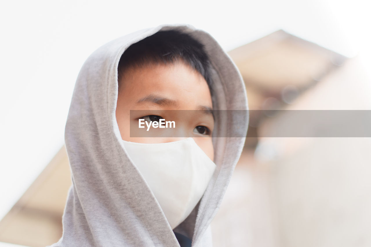 Close-up of boy wearing mask looking away