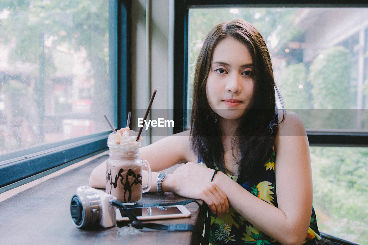 Portrait of smiling woman sitting at cafe