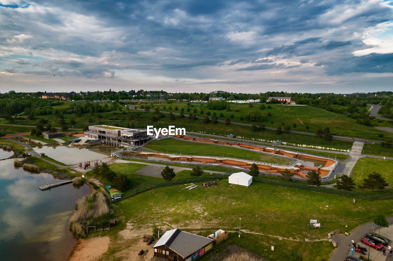 HIGH ANGLE VIEW OF HOUSES AND TREES ON FIELD