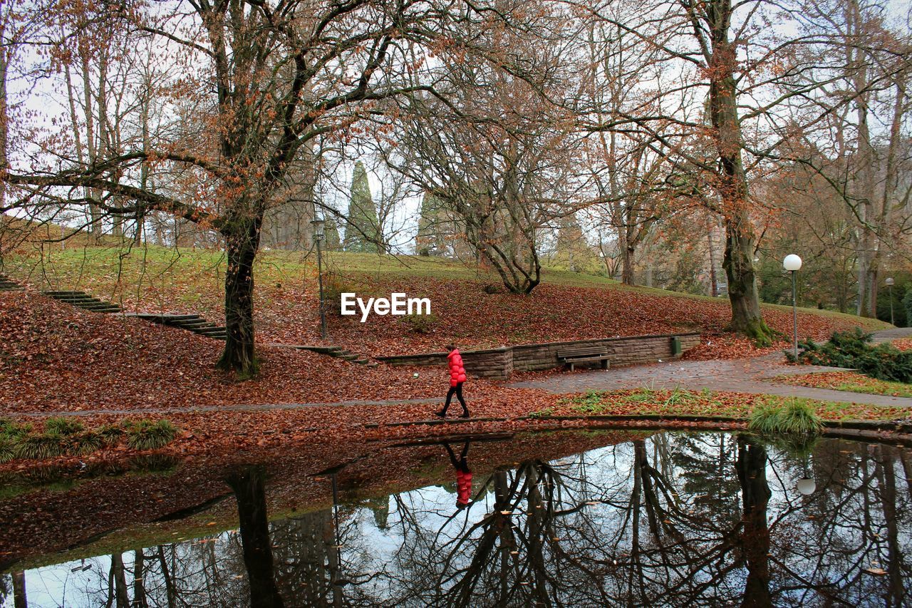 High angle view of man walking by canal during autumn