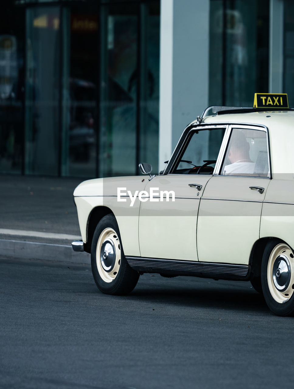 White taxi on road in city