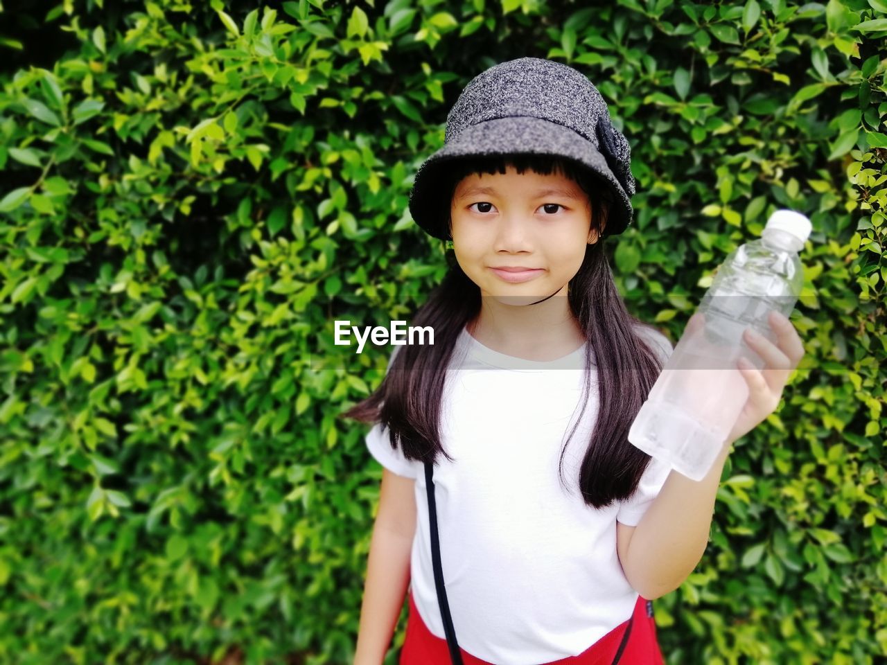 Portrait of smiling girl standing against plants