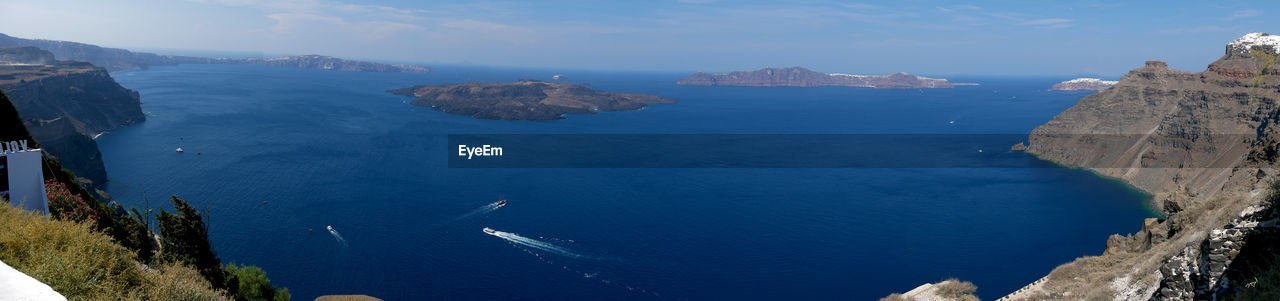 Panoramic view of sea and mountains against blue sky