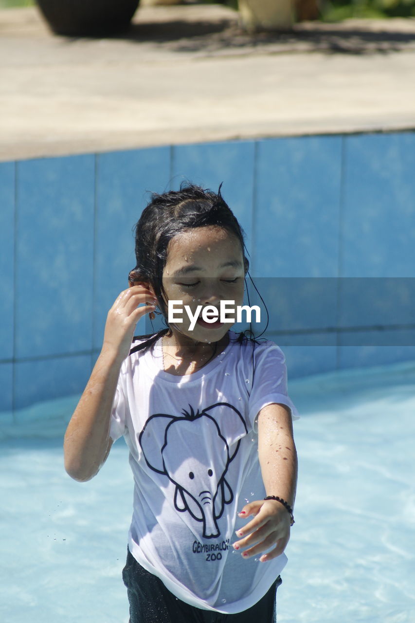 PORTRAIT OF GIRL IN SWIMMING POOL