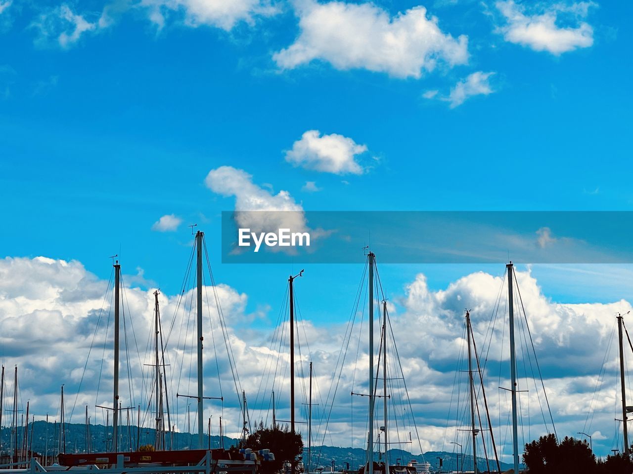 Low angle view of sailboats against blue sky