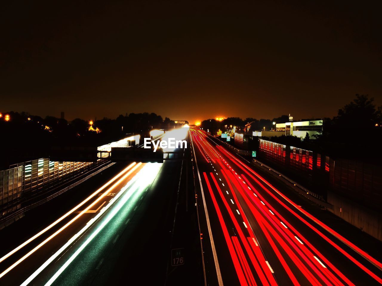 HIGH ANGLE VIEW OF LIGHT TRAILS ON HIGHWAY IN CITY AT NIGHT