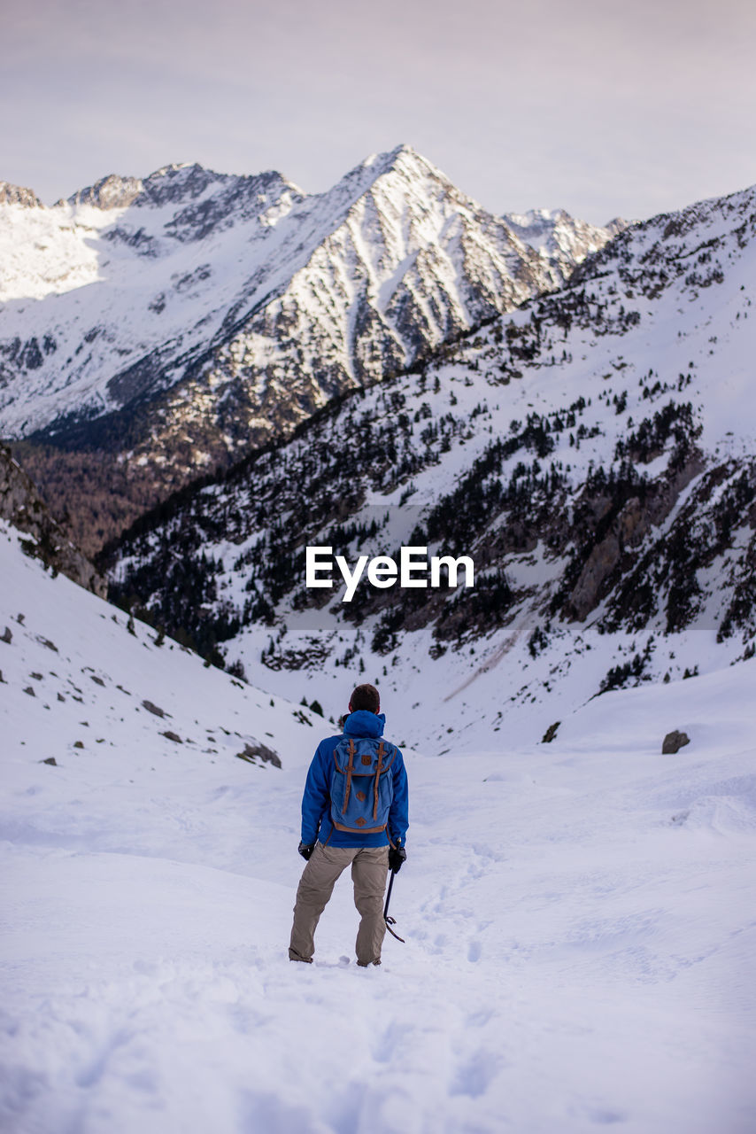 Rear view of man on snowcapped mountain