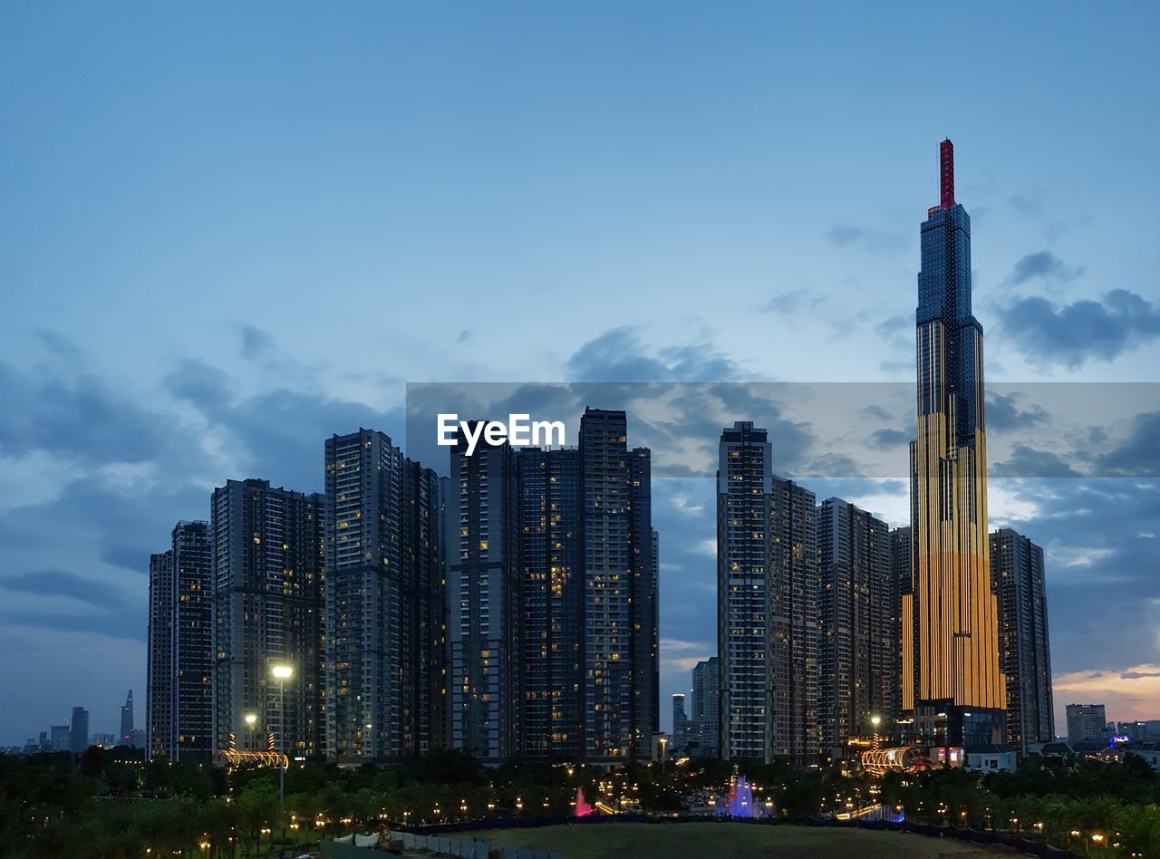 Illuminated buildings in city against sky