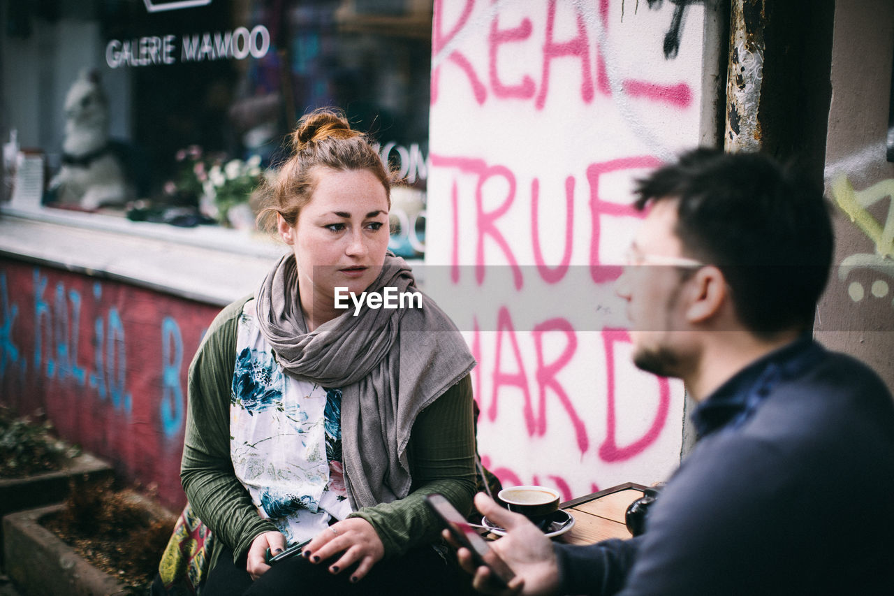 YOUNG COUPLE LOOKING AWAY WHILE SITTING IN TEXT