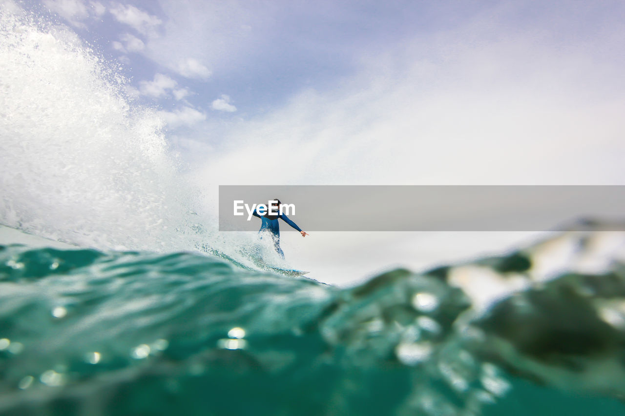 Man surfing in sea against sky