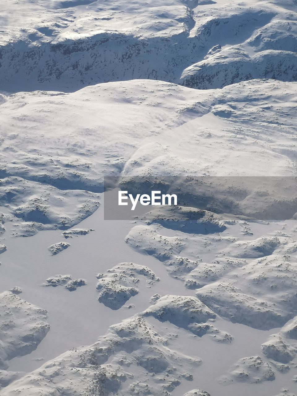 HIGH ANGLE VIEW OF SNOW COVERED LANDSCAPE AGAINST MOUNTAIN