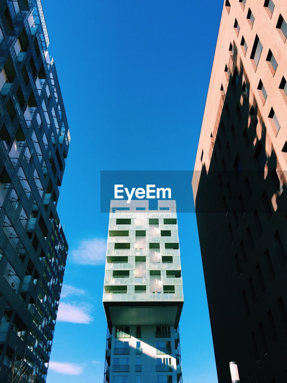 Low angle view of modern buildings against clear blue sky