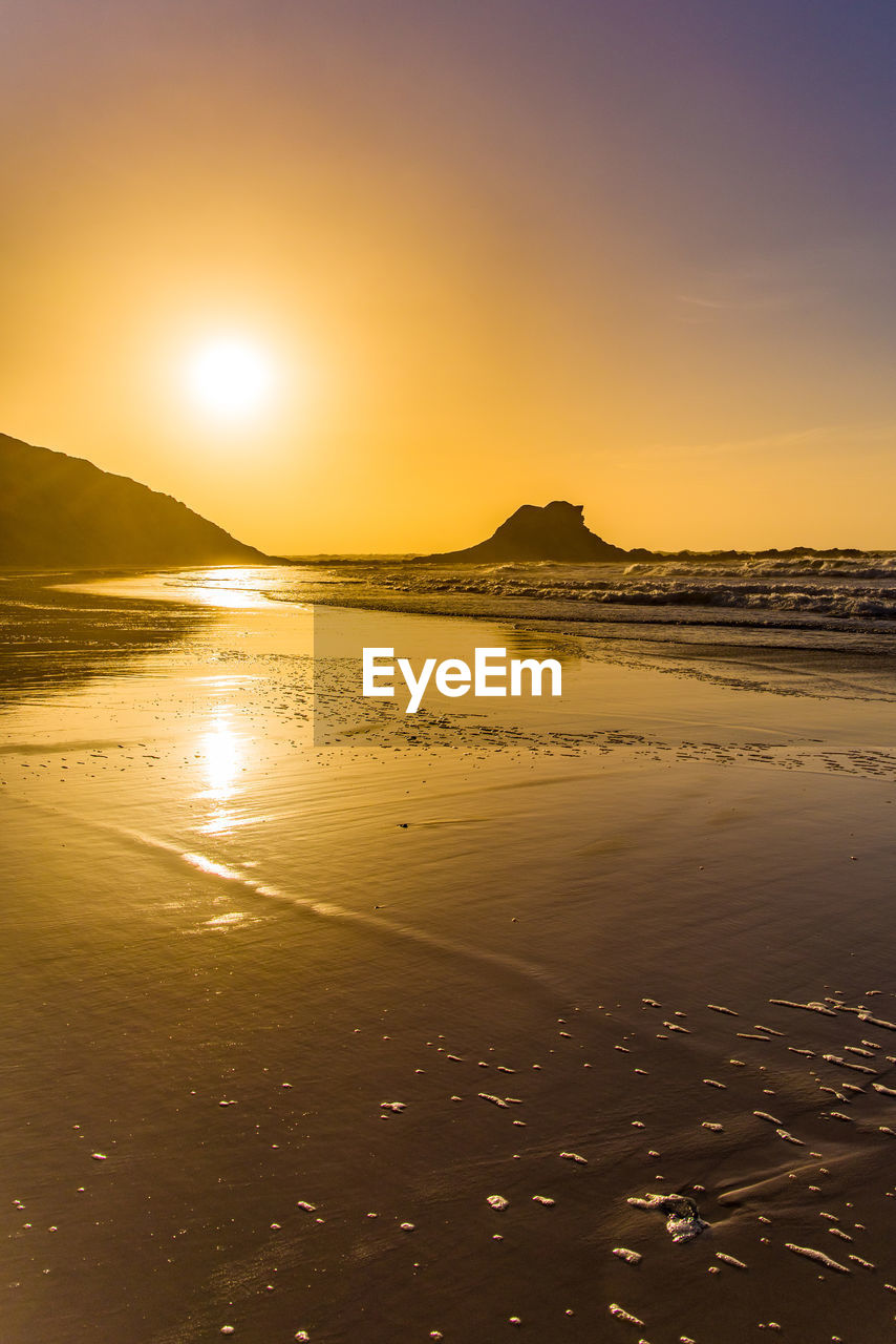 Scenic view of beach against sky during sunset