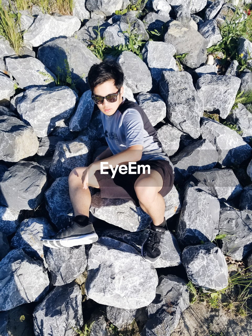 High angle view of boy sitting on rocks