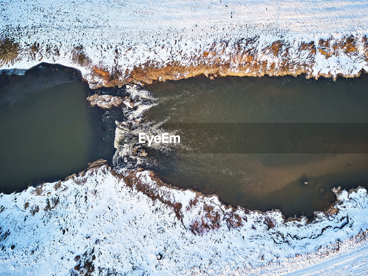 Waterfall winter creek. snow frozen riverbanks. top aerial view river cascade. stream water flowing 