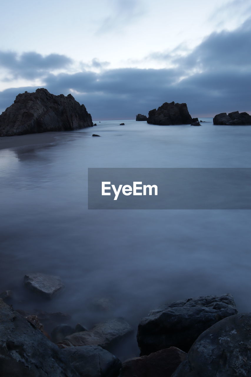 Scenic view of rocks in sea against sky