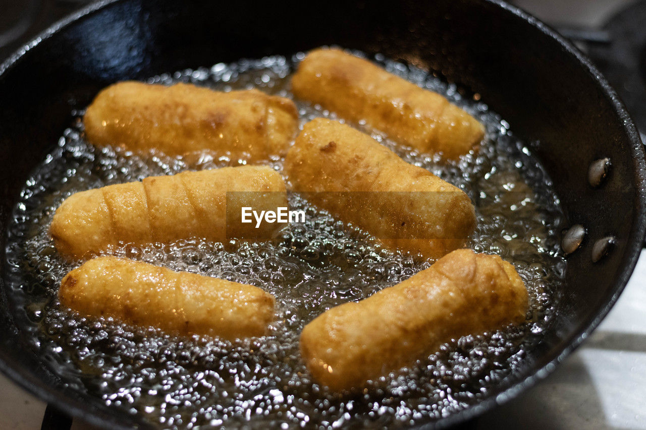 food, food and drink, fast food, dish, frying, cuisine, kitchen utensil, indoors, freshness, cooking pan, household equipment, no people, close-up, fried, dessert, produce, sugar, cooking oil, pan, oil, sweet food, unhealthy eating, still life, high angle view