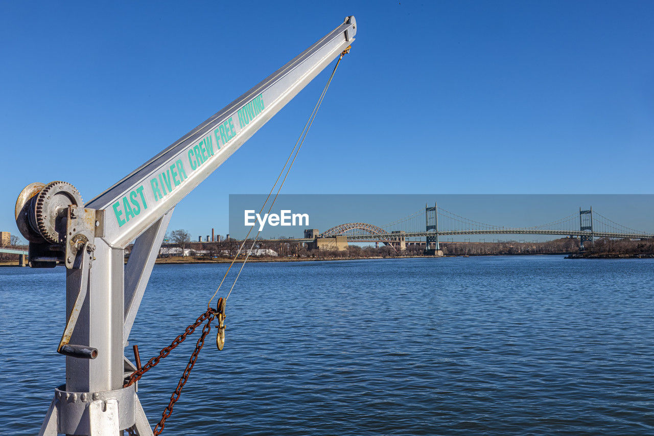 water, transportation, sky, vehicle, architecture, nature, clear sky, mast, blue, bridge, sea, built structure, nautical vessel, sailing, travel, travel destinations, no people, boat, day, mode of transportation, cable-stayed bridge, sunny, sailboat, outdoors, city, ship, copy space, tourism, sunlight, waterfront, suspension bridge, environment