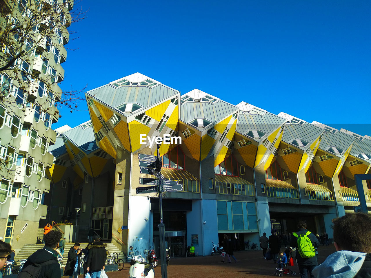LOW ANGLE VIEW OF YELLOW BUILDINGS AGAINST CLEAR BLUE SKY