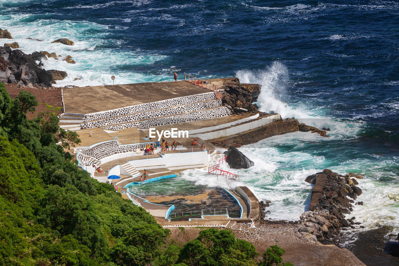 People by a seawater swimming pool foz da ribeira do guilherme on sao miguel island, azores