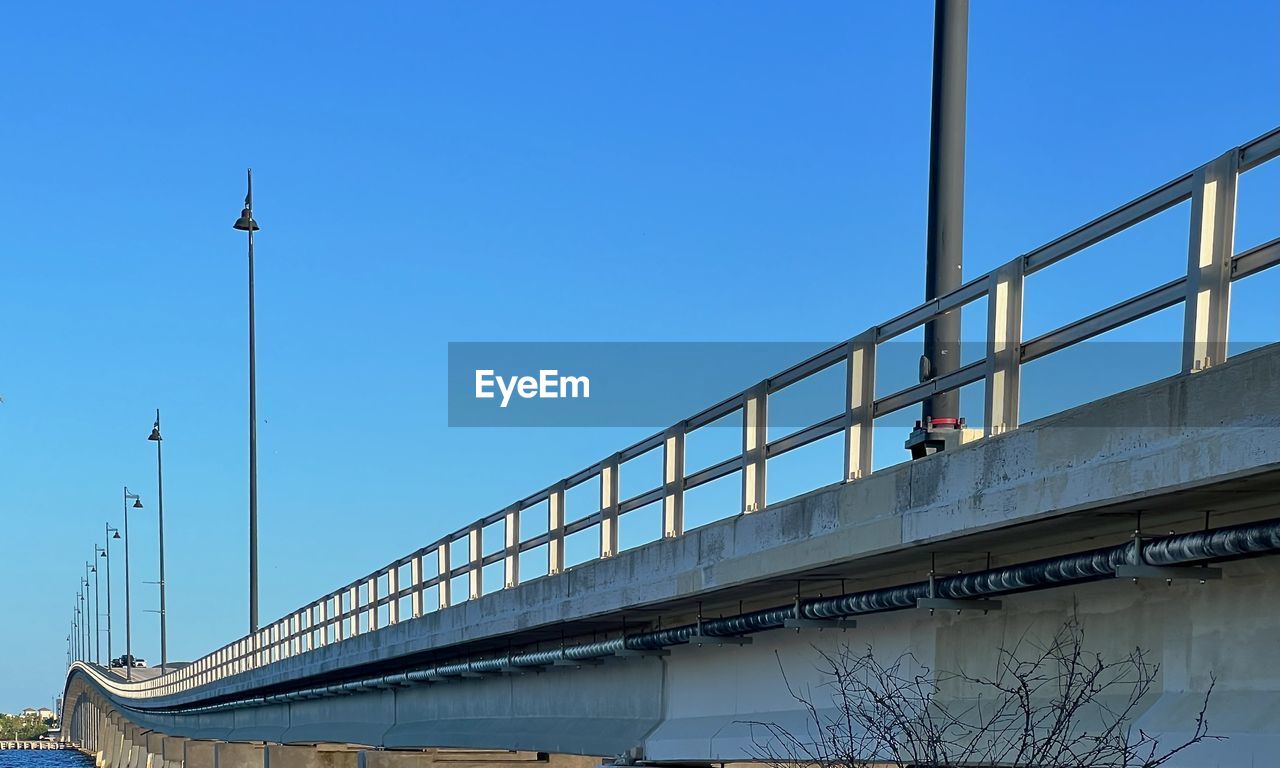 bridge, architecture, built structure, sky, transportation, clear sky, overpass, nature, transport, blue, city, water, building exterior, no people, day, cable-stayed bridge, girder bridge, travel, outdoors, travel destinations, railing, stadium, river, suspension bridge, street light, highway, low angle view