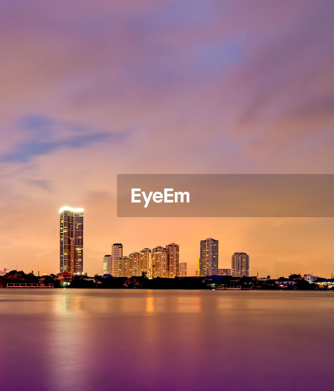 Illuminated buildings against sky during sunset