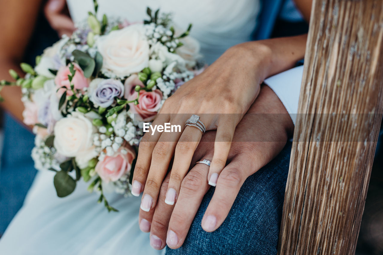 Midsection of newlywed couple holding hands in wedding ceremony