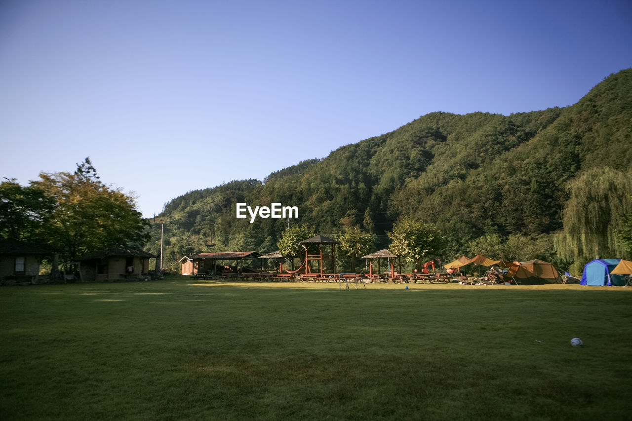 Scenic view of camping field against blue sky