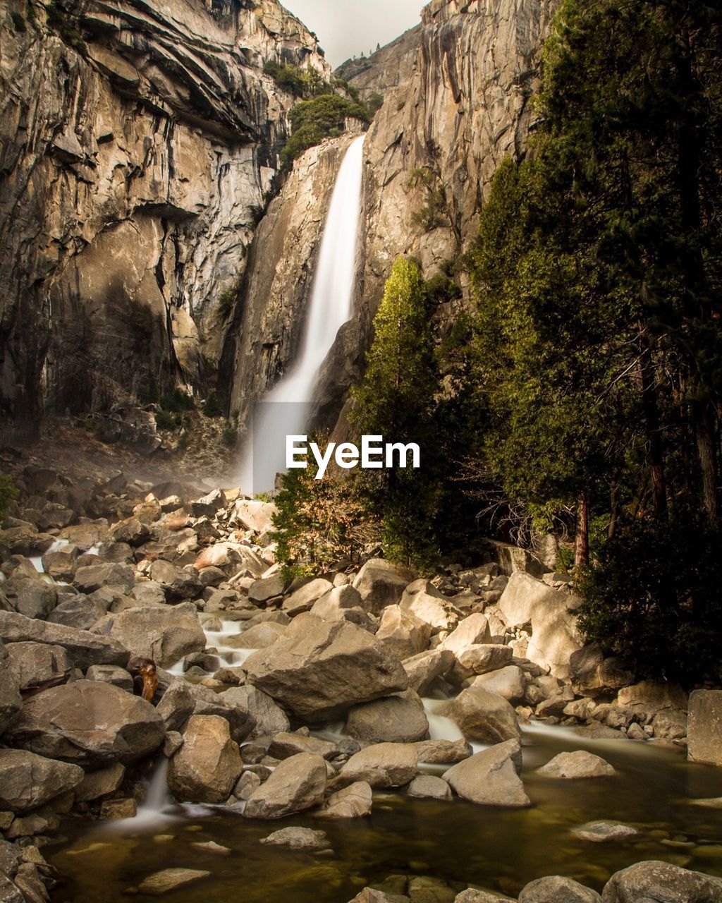 WATER FLOWING THROUGH ROCKS IN SUNLIGHT