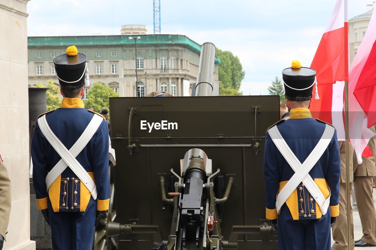 Artillerymen standing by cannon in city