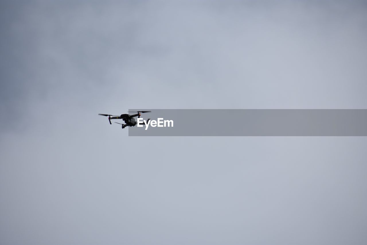 Low angle view of drone flying in sky