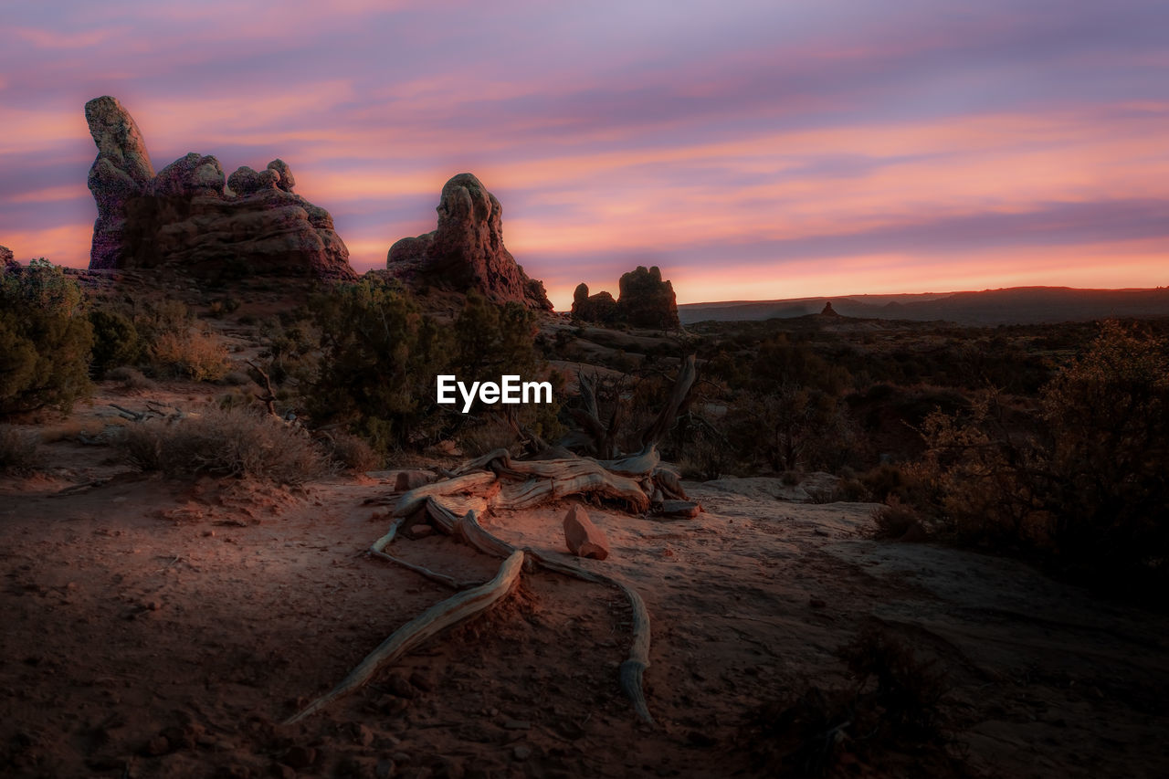 Rock formations on landscape against sky during sunset