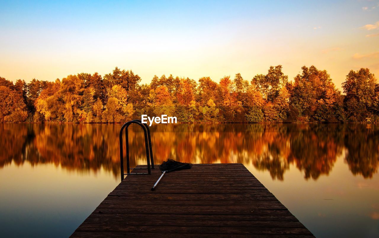 Pier amidst lake against sky during autumn