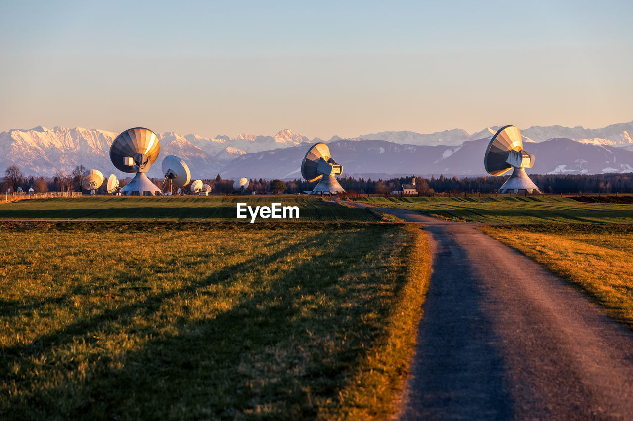 Huge parabolic antenna on a field with mountain view 