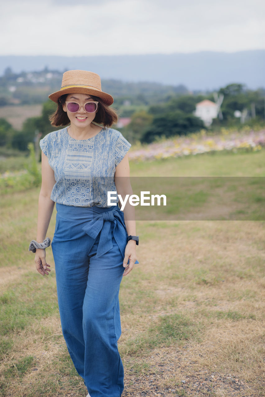 Asian woman standing outdoor with toothy smiling