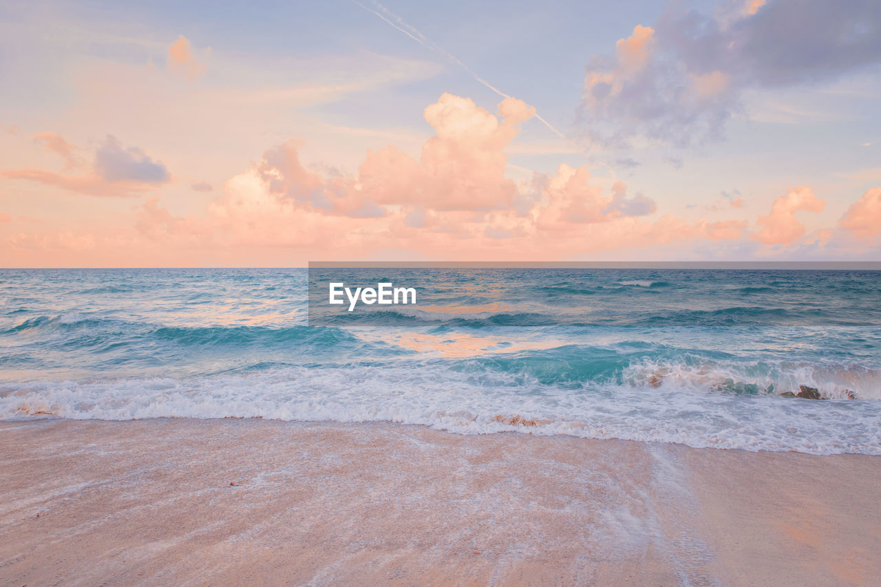 Sea ocean beach sunset sunrise landscape. water wave with foam.  sunset airy red sky with clouds