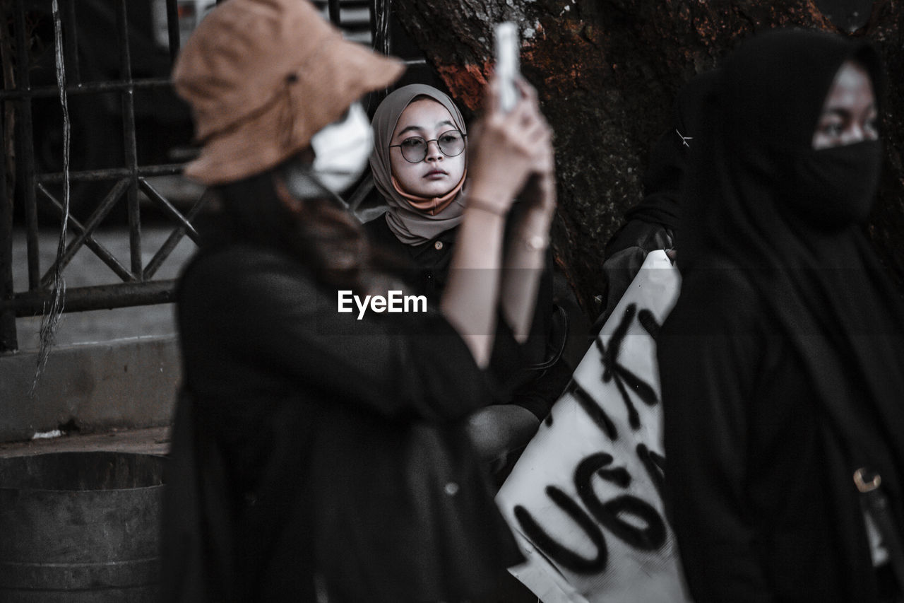 MIDSECTION OF WOMAN WEARING MASK WITH TEXT