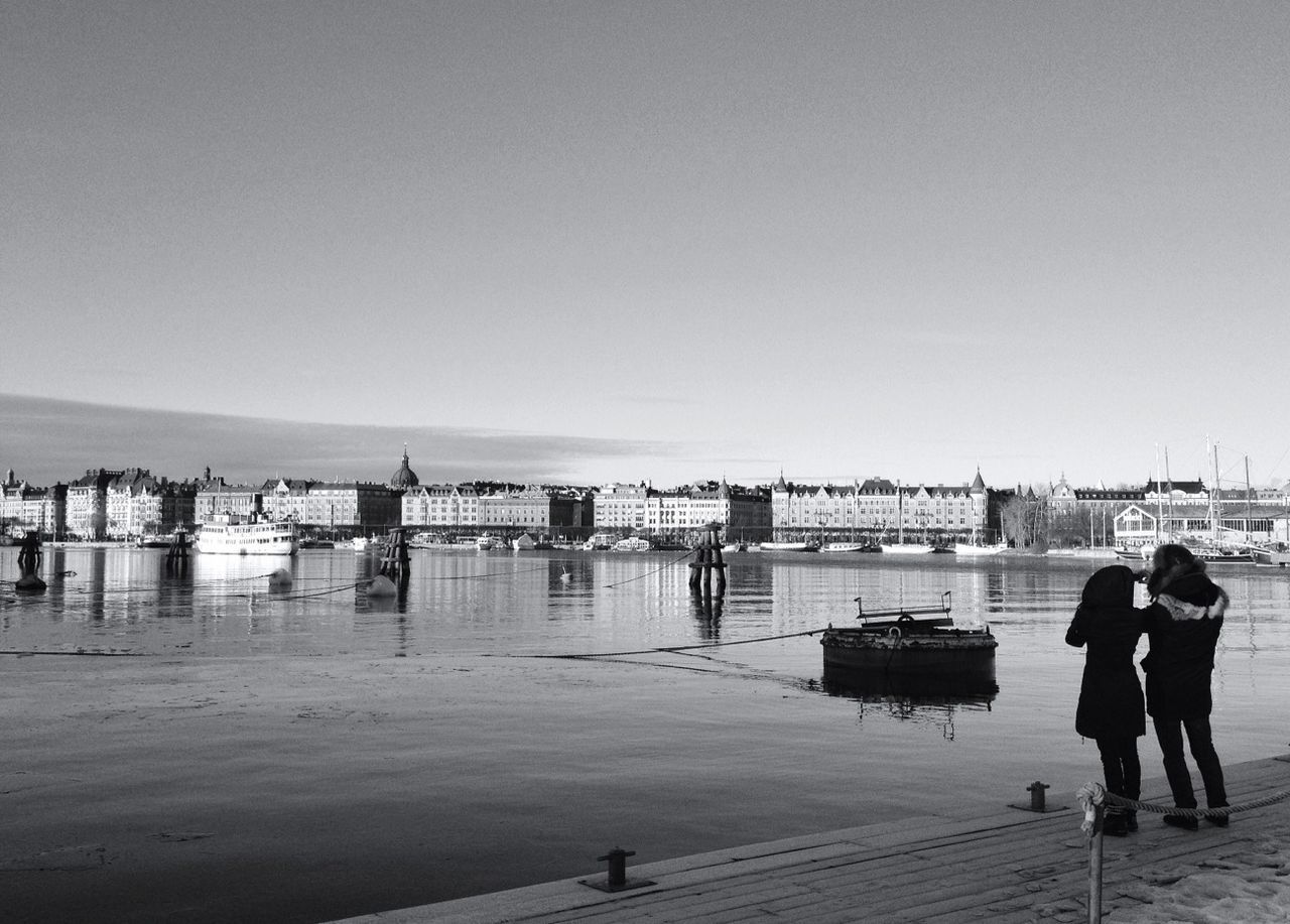 Couple at port watching cityscape