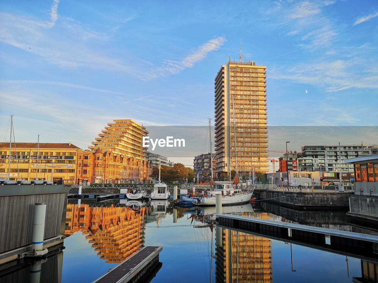 Buildings by river against sky in city