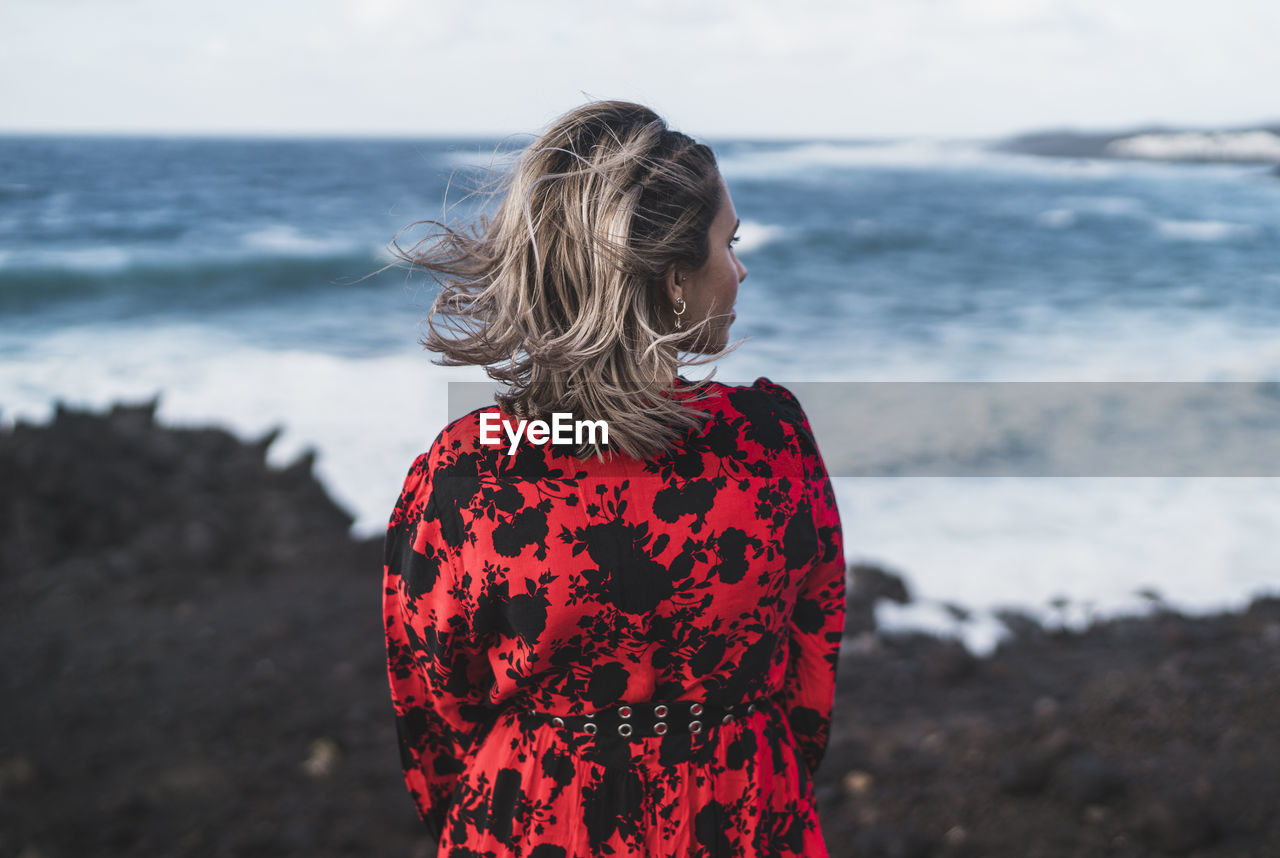 Young woman looking at view while standing at el golfo, lanzarote, spain