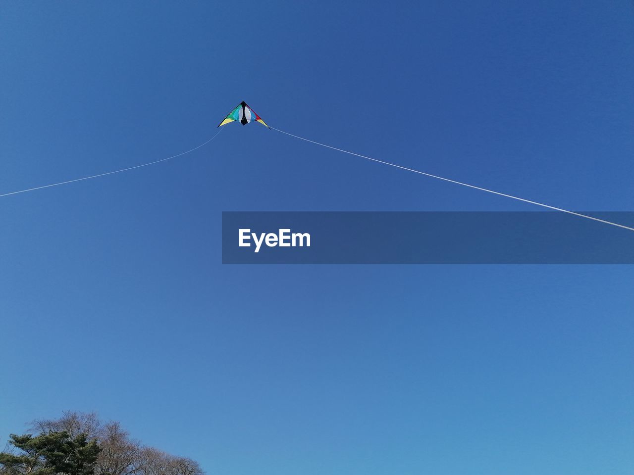 sky, blue, clear sky, low angle view, nature, toy, flying, sports, kite - toy, day, vapor trail, kite sports, windsports, copy space, mid-air, sunny, rope, leisure activity, motion, outdoors, adventure, one person, kite, extreme sports, cloud, transportation, air vehicle, environment