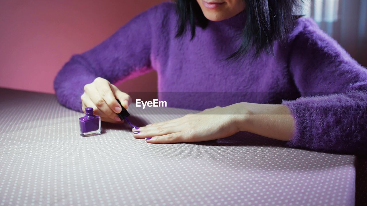 Close-up of woman applying nail polish