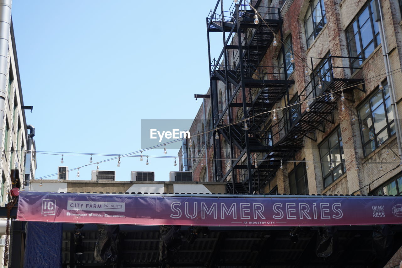 LOW ANGLE VIEW OF INFORMATION SIGN AGAINST BUILDINGS