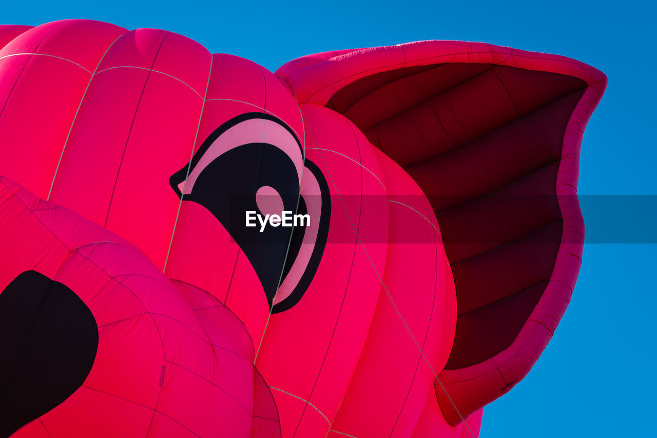 LOW ANGLE VIEW OF MULTI COLORED HOT AIR BALLOON AGAINST BLUE SKY