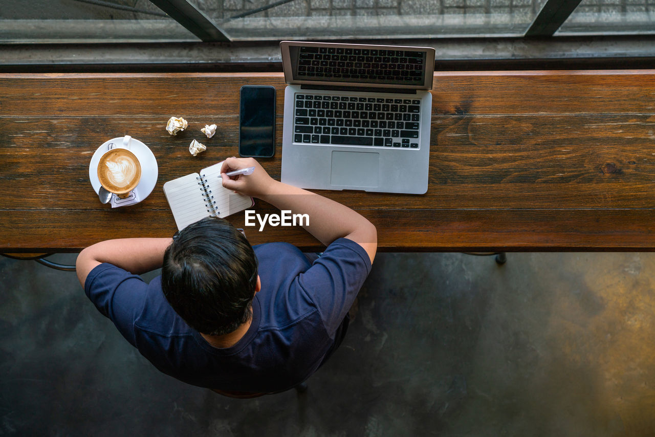 High angle view of man using laptop on table