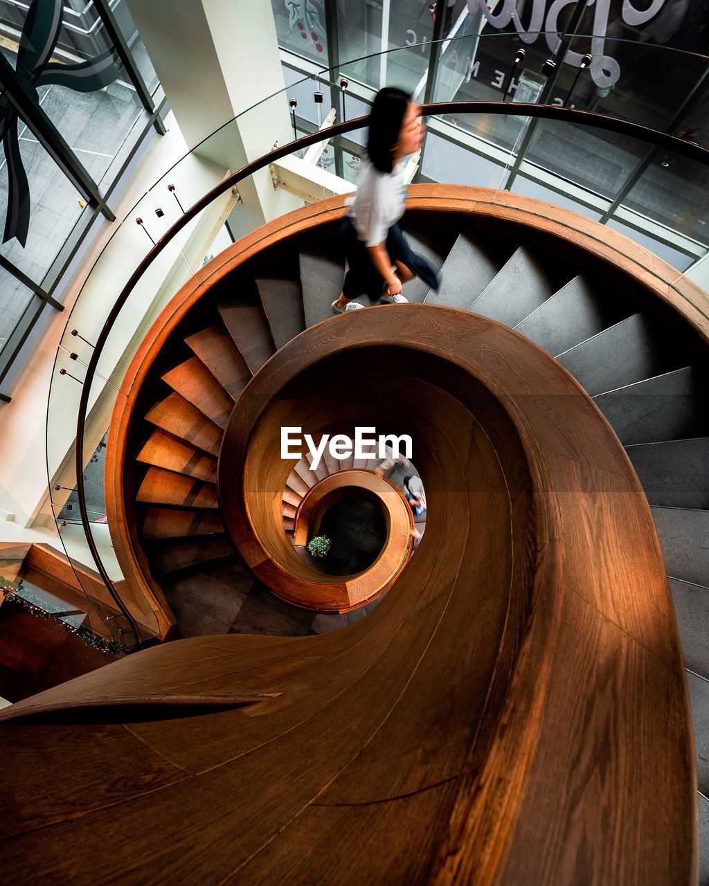 High angle view of woman climbing on spiral staircase